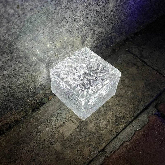 Set of 4 waterproof solar garden lights in decorative ice cube design glowing warmly outdoors